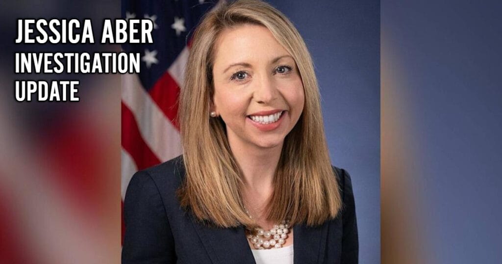 Jessica aber, former u. S. Attorney for the eastern district of virginia, in official portrait with american flag background.