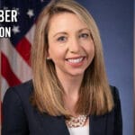Jessica aber, former u. S. Attorney for the eastern district of virginia, in official portrait with american flag background.
