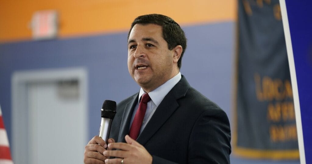 Wisconsin attorney general josh kaul speaks into a microphone at a public event.